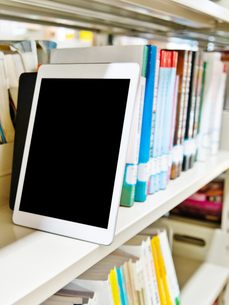En tablet i en bokhylla